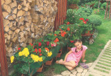 „Moja wnuczka Kornelka na tle drewutni i kwitnących begonii”, pisze nasza czytelniczka