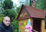 Drewniany ręcznie robiony  domek stojący pośród zieleni ,to prezent na pierwsze urodziny naszego maluszka.