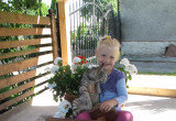 Córka Julia w kwietniku samochodzie z pelargoniami i kotkiem