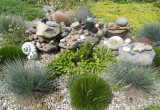 polne kamienie i figurki ogrodowe wśród konstelacji traw.