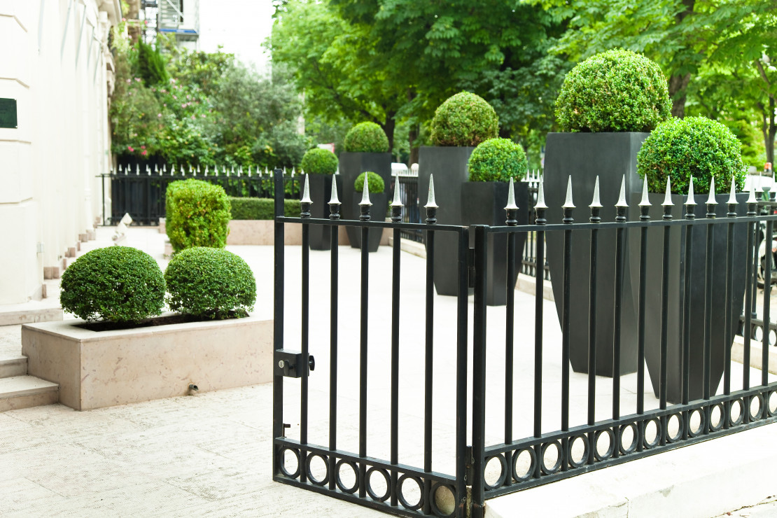 Eleganckie ogrodzenie miejskiej posesji wykonane z żelaznych przęseł