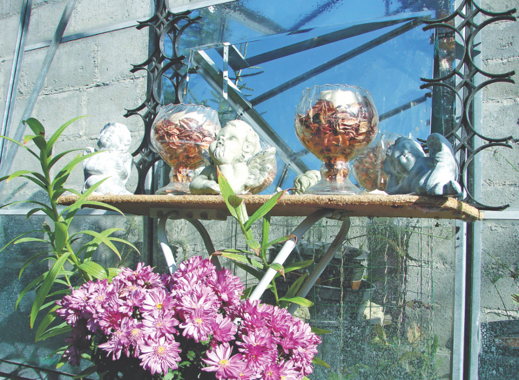 Szklarnia jest dodatkowo udekorowana wiszącymi dzwonkami, figurkami i kielichami wypełnionymi ususzonymi kwiatami.