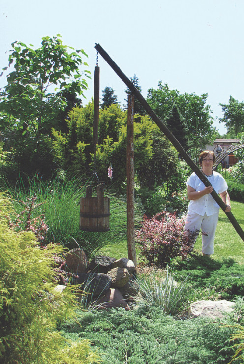 Wodę do kwiatów czerpiemy drewnianym żurawiem.