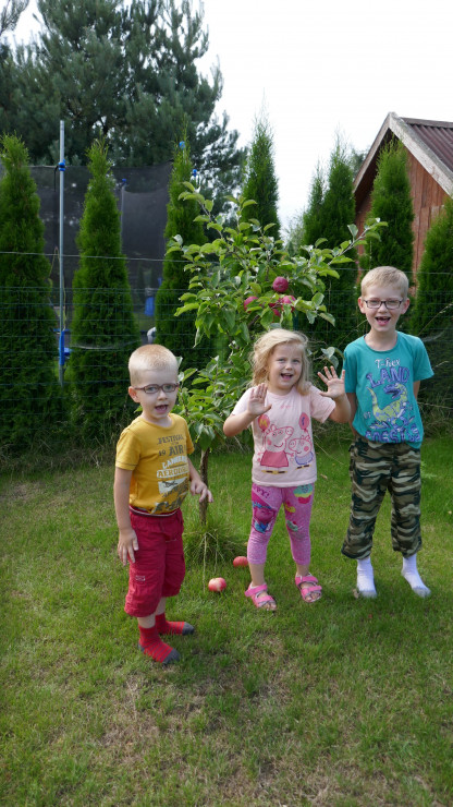 Dzieci uwielbiają pozować przy drzewkach np przy jabłonce